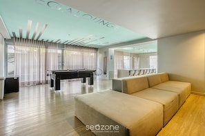 Un salon moderne doté d’une table de billard, d’un canapé et d’un plafond au design original.