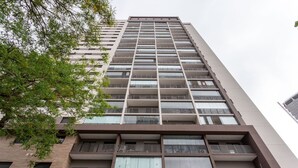 Un immeuble à plusieurs étages doté d’une architecture moderne, avec des balcons et de grandes fenêtres.