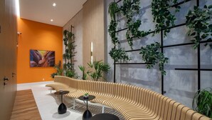 Un intérieur moderne avec un canapé aux lignes courbes, un mur décoré de plantes et un tableau.