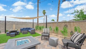 Un jardin avec un foyer, du mobilier d’extérieur et un mur en briques.