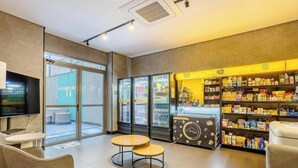A modern interior with seating, a vending machine, and a snack bar. - Studio w/ Balcony and View in Consolacao - Vno1417 (São Paulo)