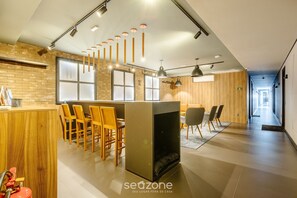 A modern hotel lobby with a bar, seating area, and a long corridor.