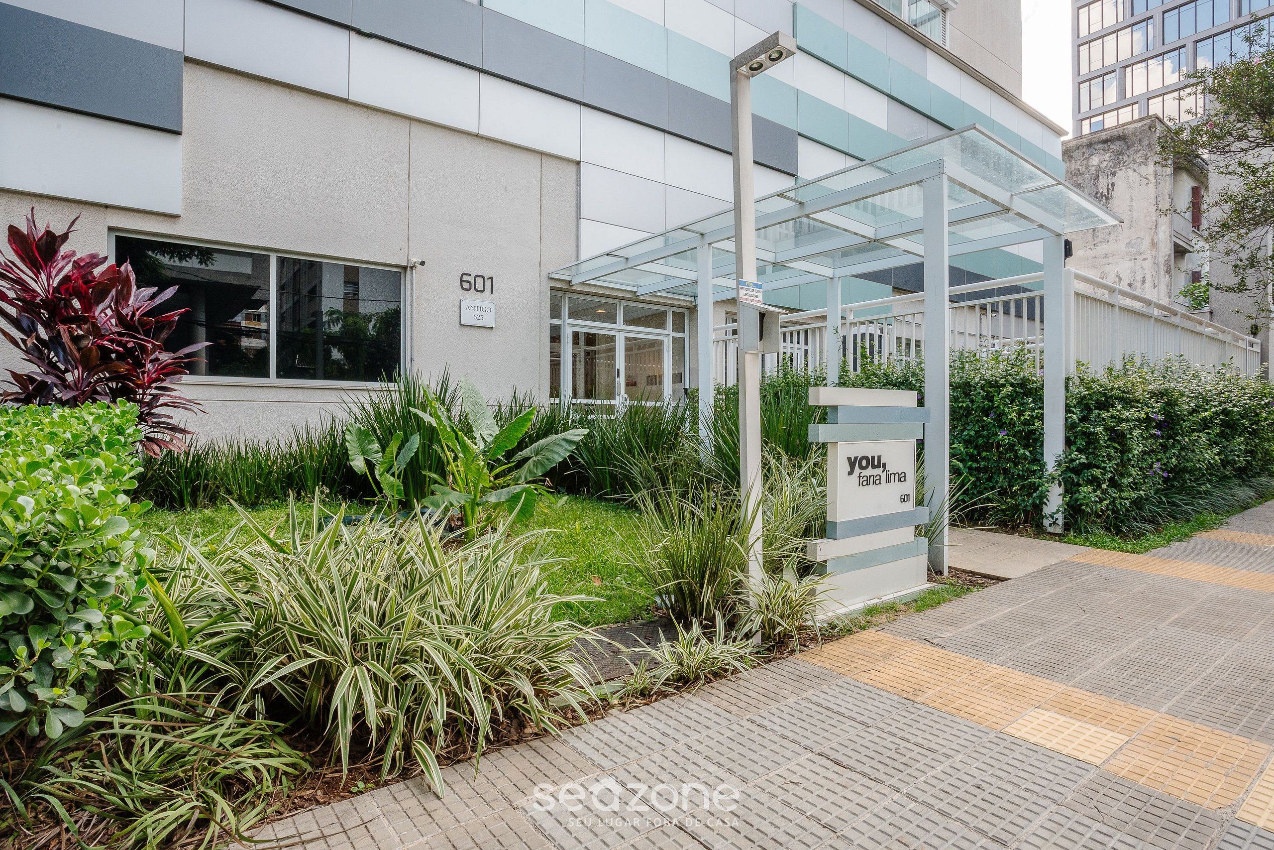 A modern building with a glass entrance and a sign that reads "601 ANTIQ."