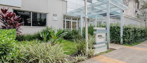 A modern building with a glass entrance and a sign that reads "601 ANTIQ."