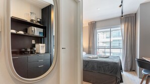 A modern bedroom with a bed, a desk, and a built-in wardrobe. - Modern Studio With Pool in Sao Paulo You1203 (São Paulo)