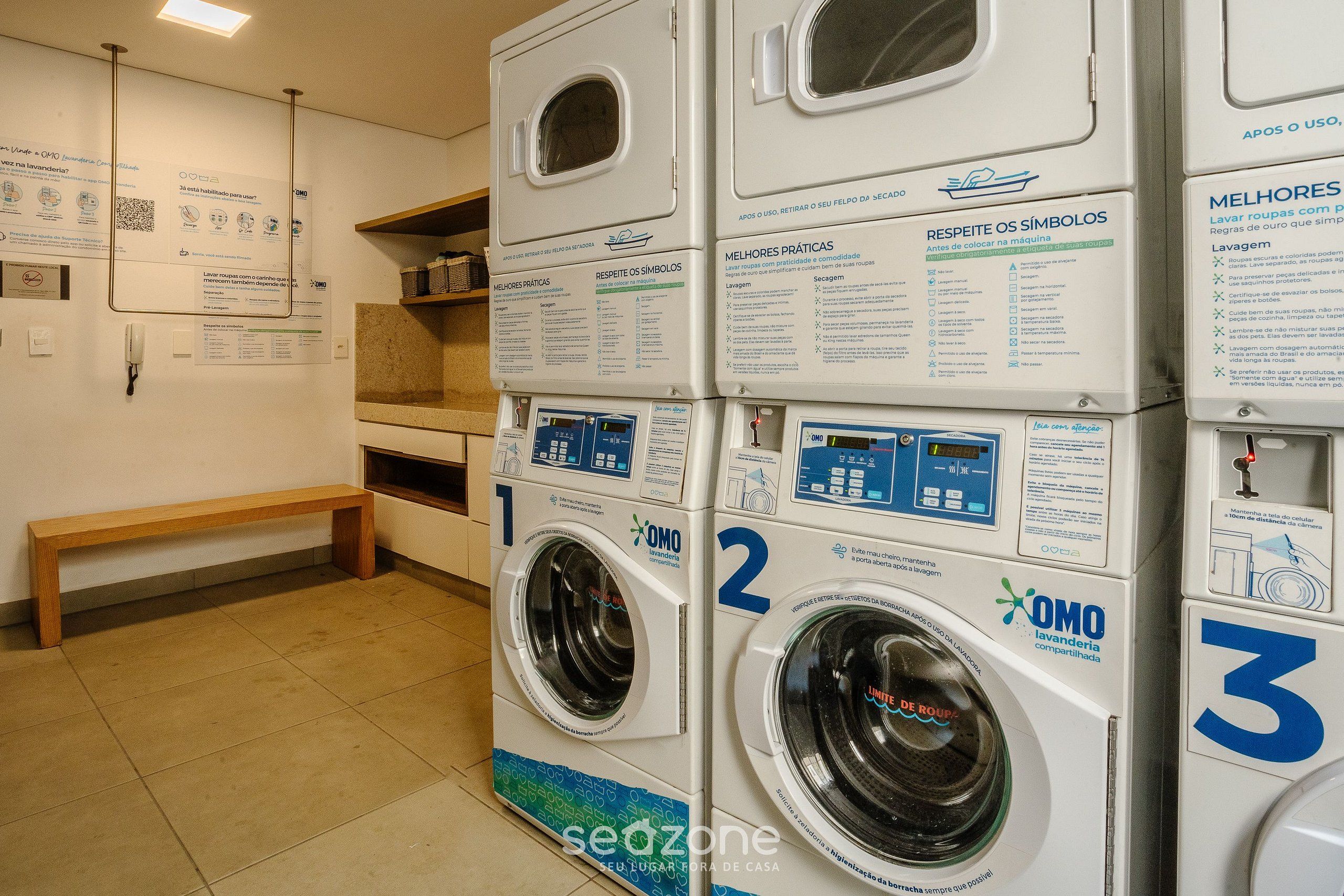 A laundry facility with three washing machines, each with a control panel and usage instructions.