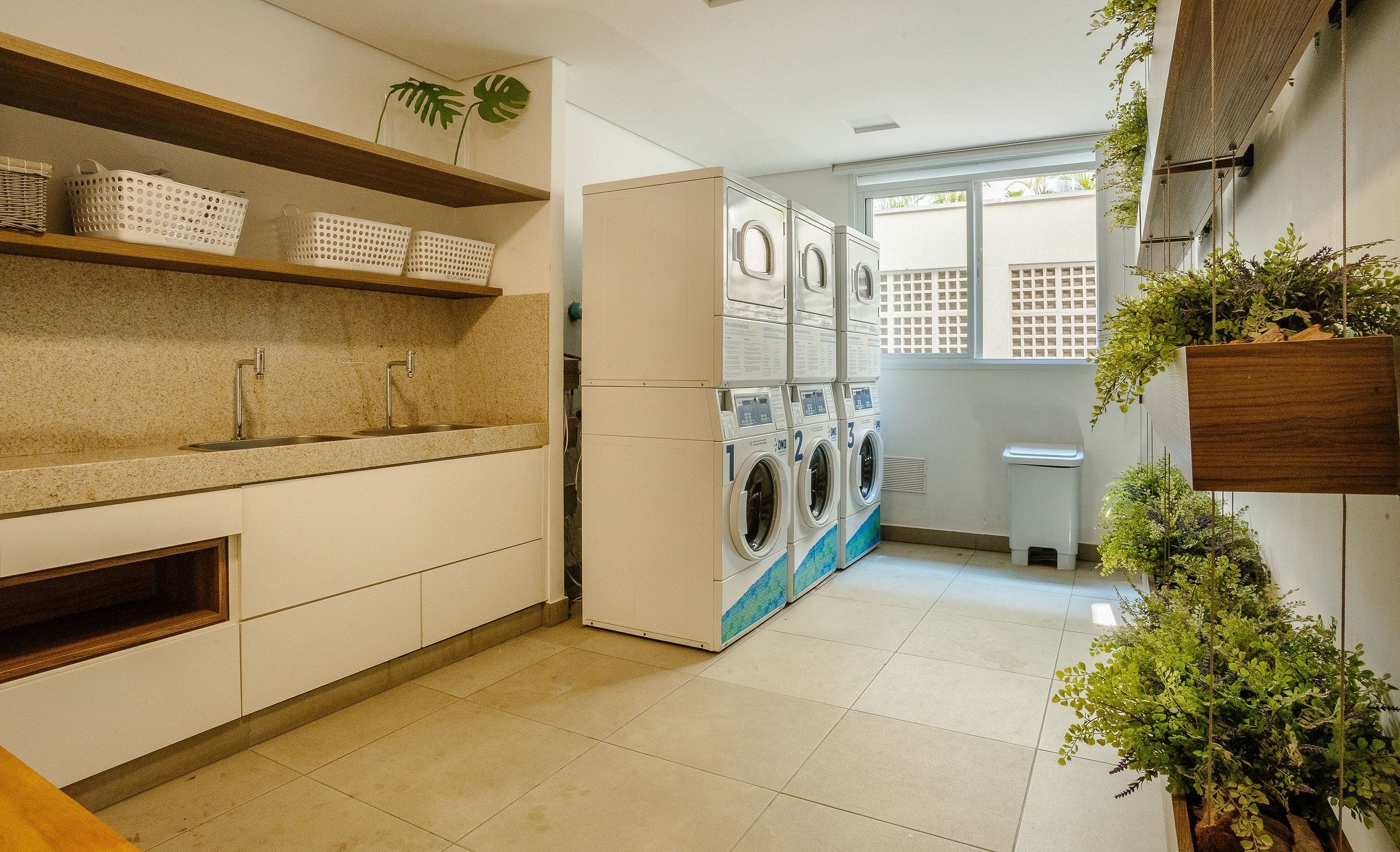A laundry area with a washing machine and dryer, a sink, and shelves with baskets.