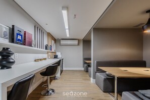 A modern office space with a white desk, black chairs, a wooden table, and a grey sofa. - Modern Studio Just Minutes From Ibirapuera Vbm1313 (São Paulo)