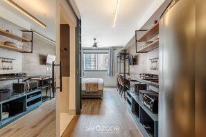 A modern kitchen with built-in appliances, wooden flooring, and a central island. - Modern Studio Just Minutes From Ibirapuera Vbm1313 (São Paulo)