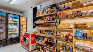 A grocery store with shelves stocked with snacks, beverages, and household items.