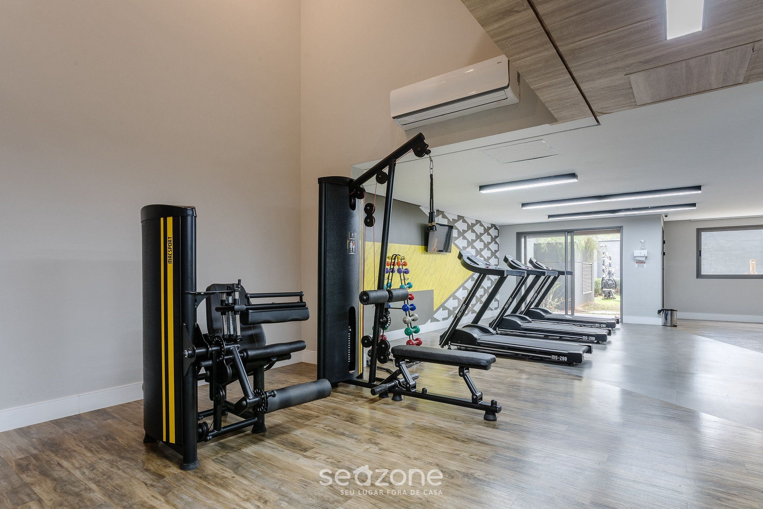 A gym with treadmills, weight machines, and a punching bag.