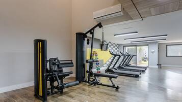 A gym with treadmills, weight machines, and a punching bag.