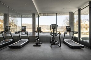 A gym with treadmills, a stationary bike, and a rowing machine.