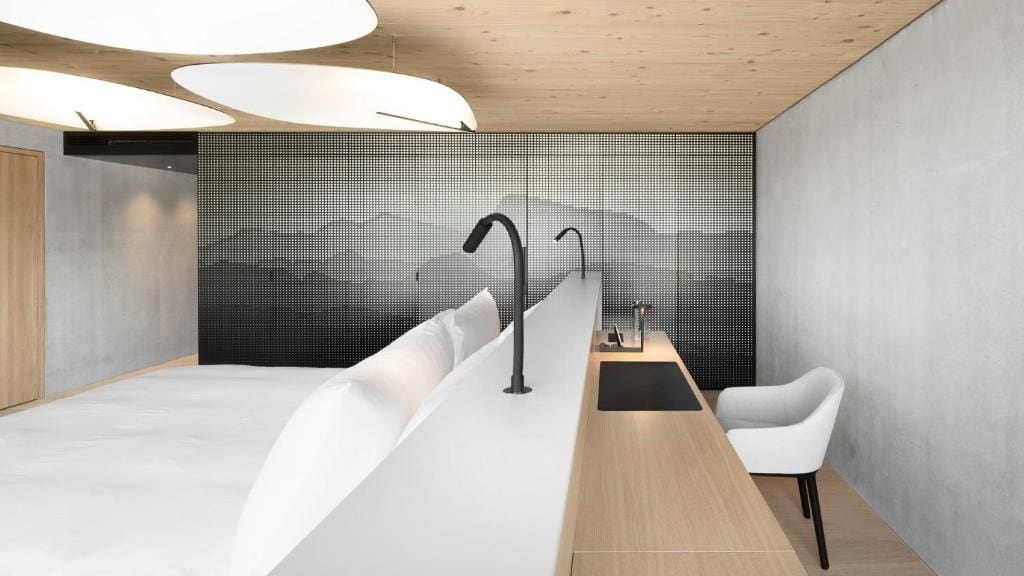 A modern bathroom with a shower, a sink, and a chair.