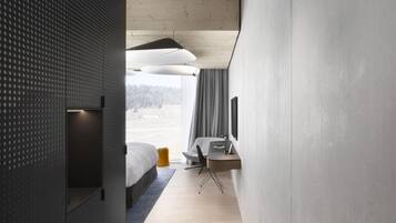 A modern hotel room with a bunk bed, a desk, and a chair.