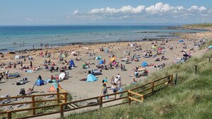 A beach with tents, people, and a wooden walkway. - Clarin Rest, luxury private room, Clarinbridge Wild Atlantic Way, Galway. (Co Galway)