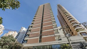 Un edificio alto y moderno con un diseño arquitectónico único, caracterizado por patrones curvos y angulares.