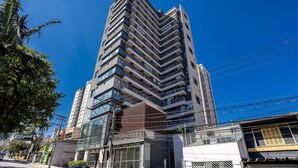 A modern high-rise building with multiple balconies and large windows.