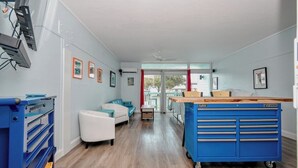 A room with a white sofa, a blue workbench, and a window with a view.