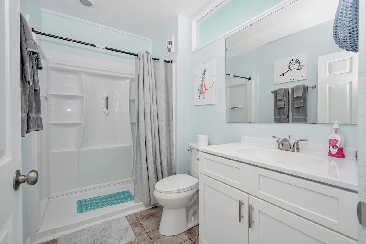 Une salle de bain équipée d’une douche, de toilettes, d’un lavabo et de meubles de rangement.