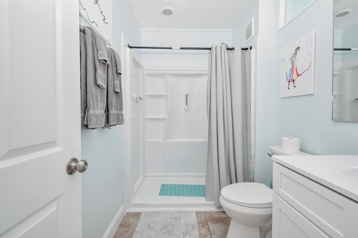 A bathroom with a shower, toilet, and sink.