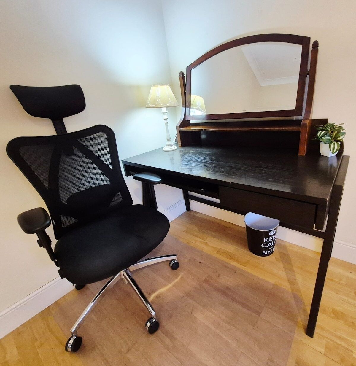 Ein Holztisch mit einem Stuhl, einer Lampe und einem kleinen Blumentopf.