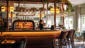 Eine Bar mit Bartender, Theke und Sitzgelegenheiten.