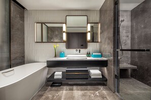 Une salle de bain moderne dotée d’une grande baignoire, d’un meuble-lavabo à deux vasques et d’une douche à parois de verre.
