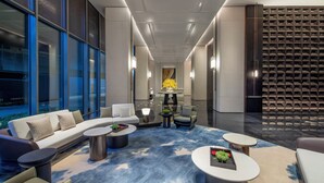 A modern hotel lobby with a sofa, chairs, a coffee table, and a patterned carpet. - Crowne Plaza Beijing Tongzhou by IHG (Tongzhou)