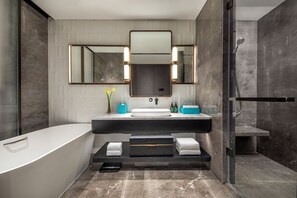 Une salle de bain moderne avec une baignoire sur pieds, un grand miroir et un espace douche.