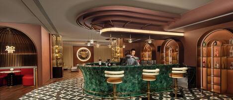 A bar area with a curved counter, three stools, and a bartender.
