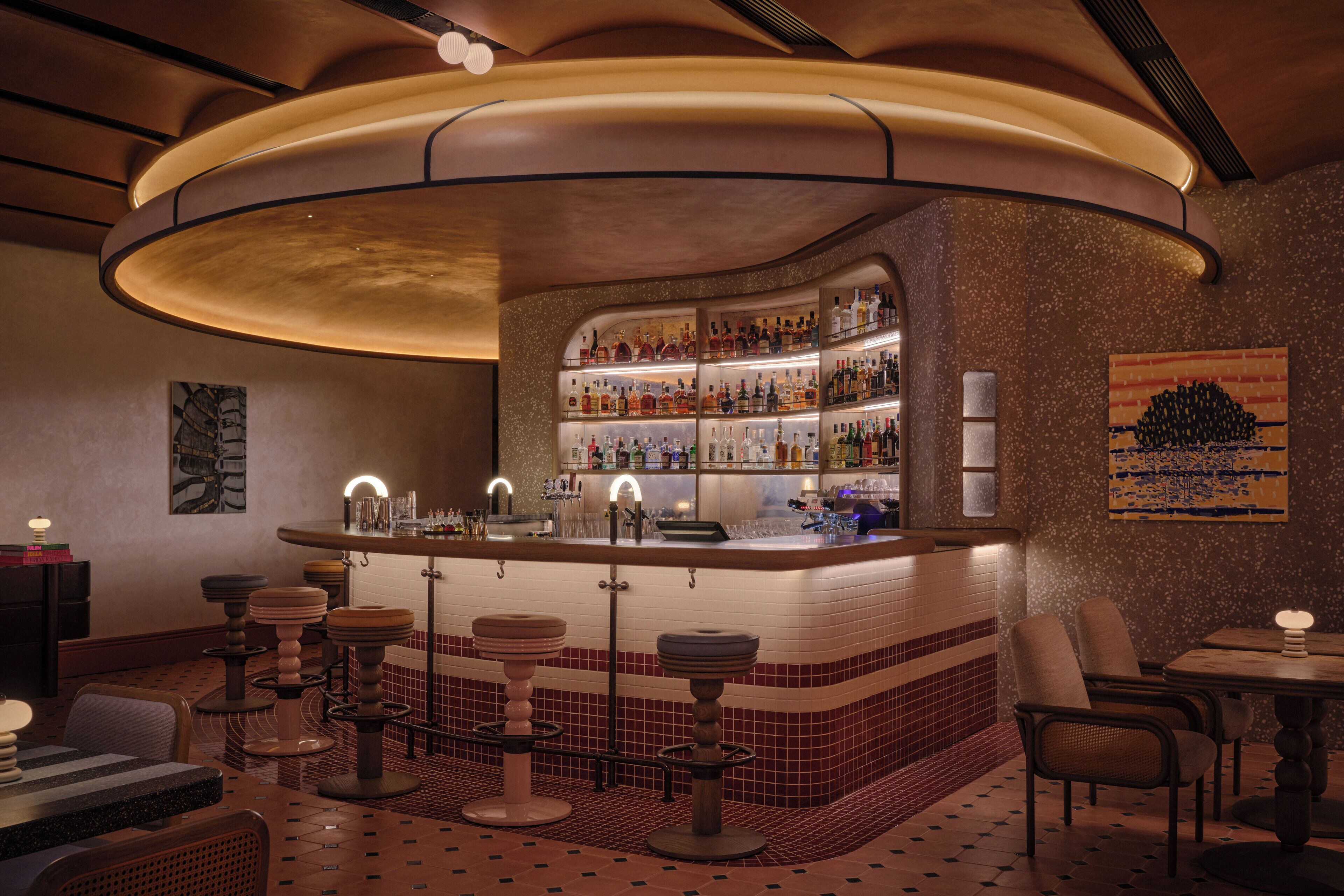A bar area with a curved counter, stools, and a tiled floor.