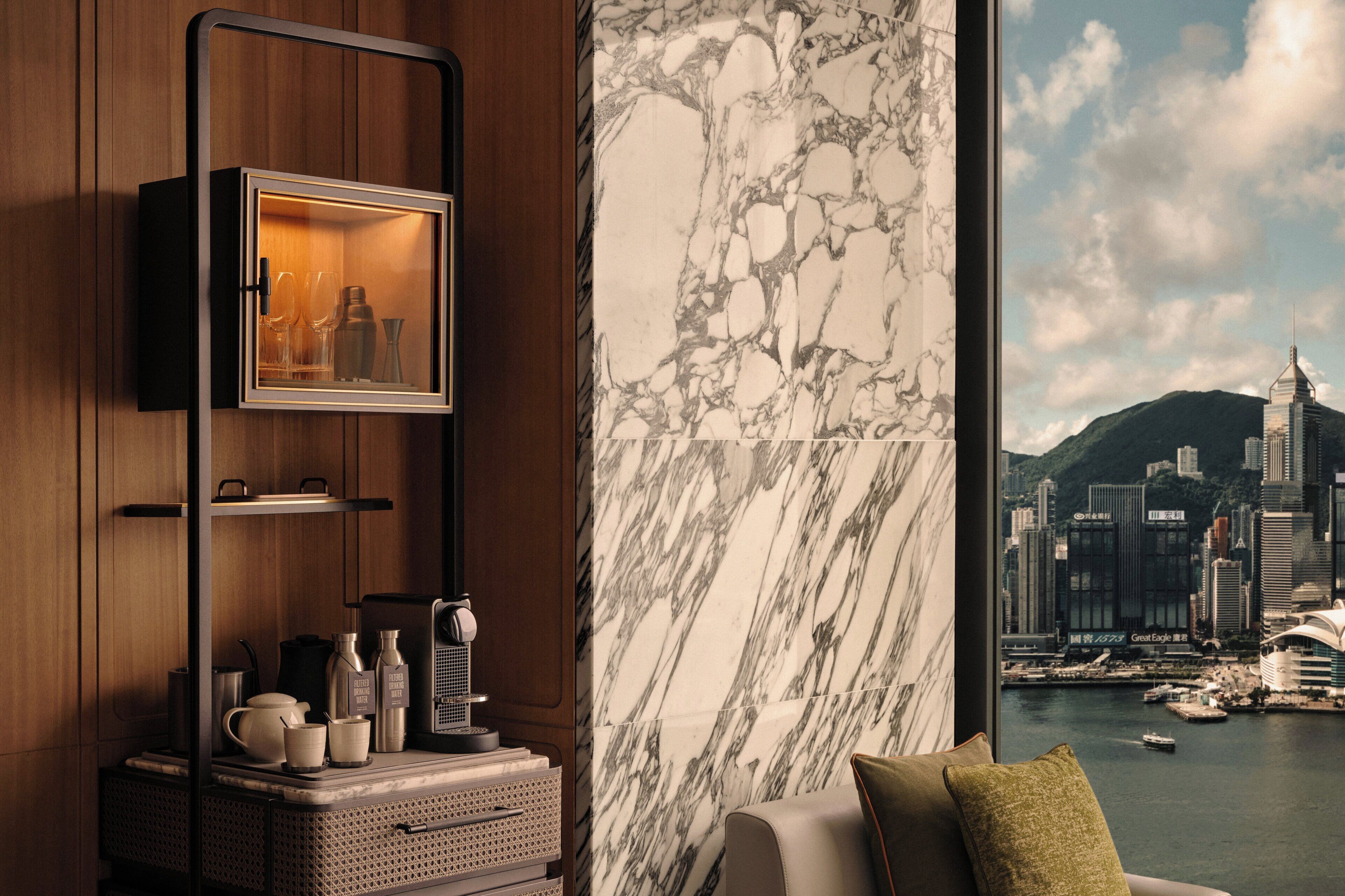 A modern room with a city view, a marble wall, and a television mounted on the wall.