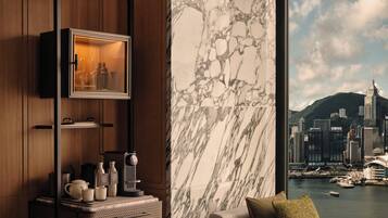 A modern room with a city view, a marble wall, and a television mounted on the wall.