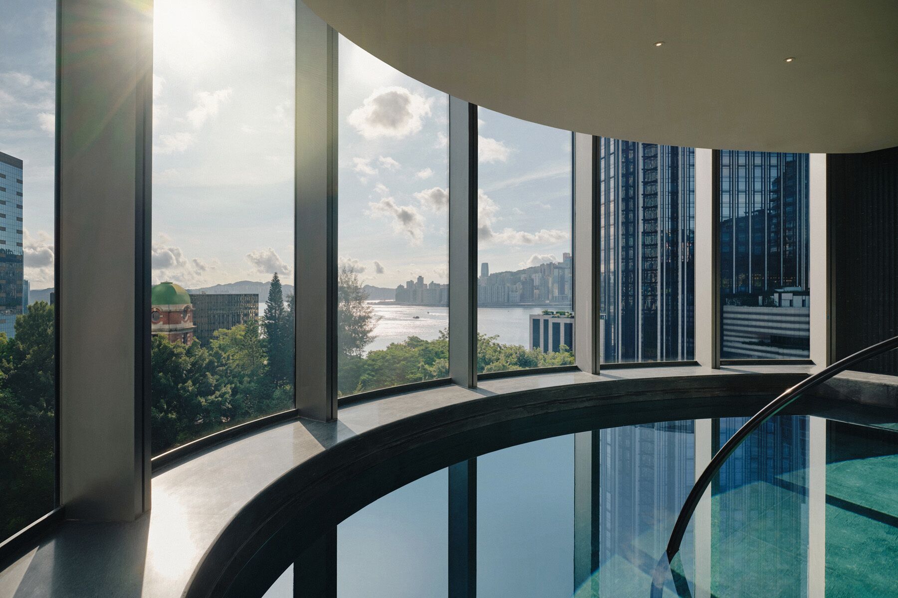A modern interior with large windows offering views of a cityscape and a river.