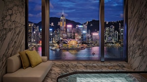 A modern interior with a sofa, a glass-enclosed jacuzzi, and a large window offering a cityscape view. - Kimpton Tsim Sha Tsui Hong Kong by IHG (Kowloon)