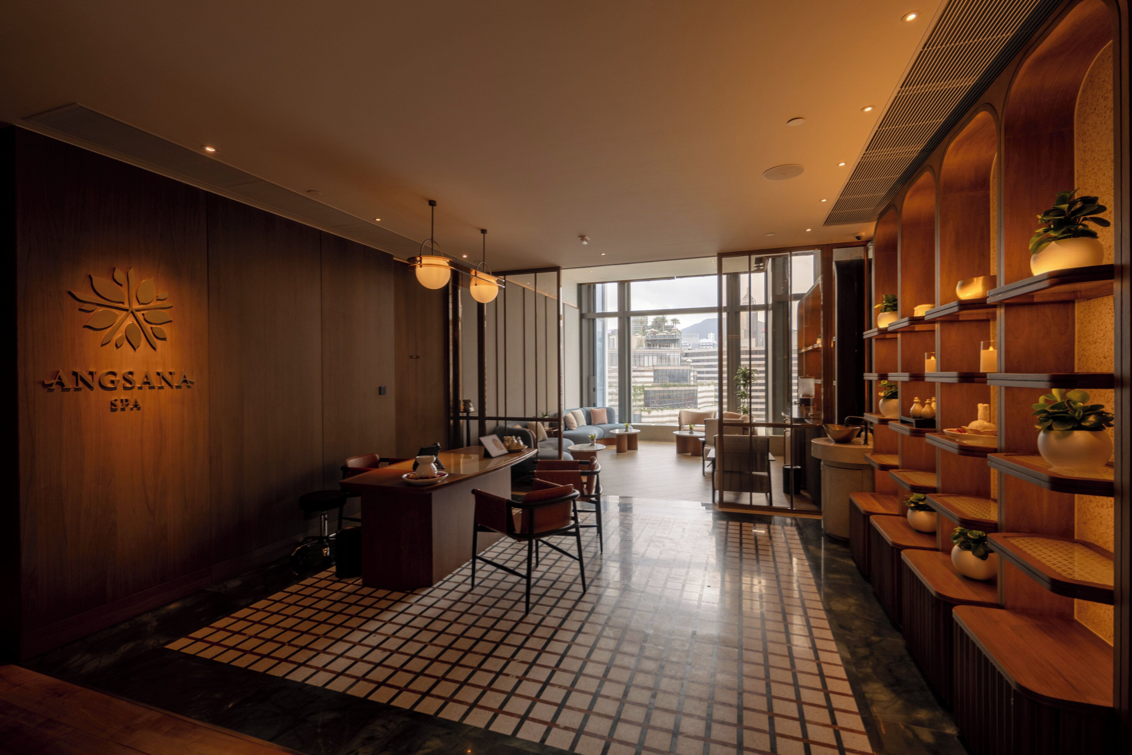 Et moderne spa-interiør med reception, loungeområde og reoler med potteplanter.