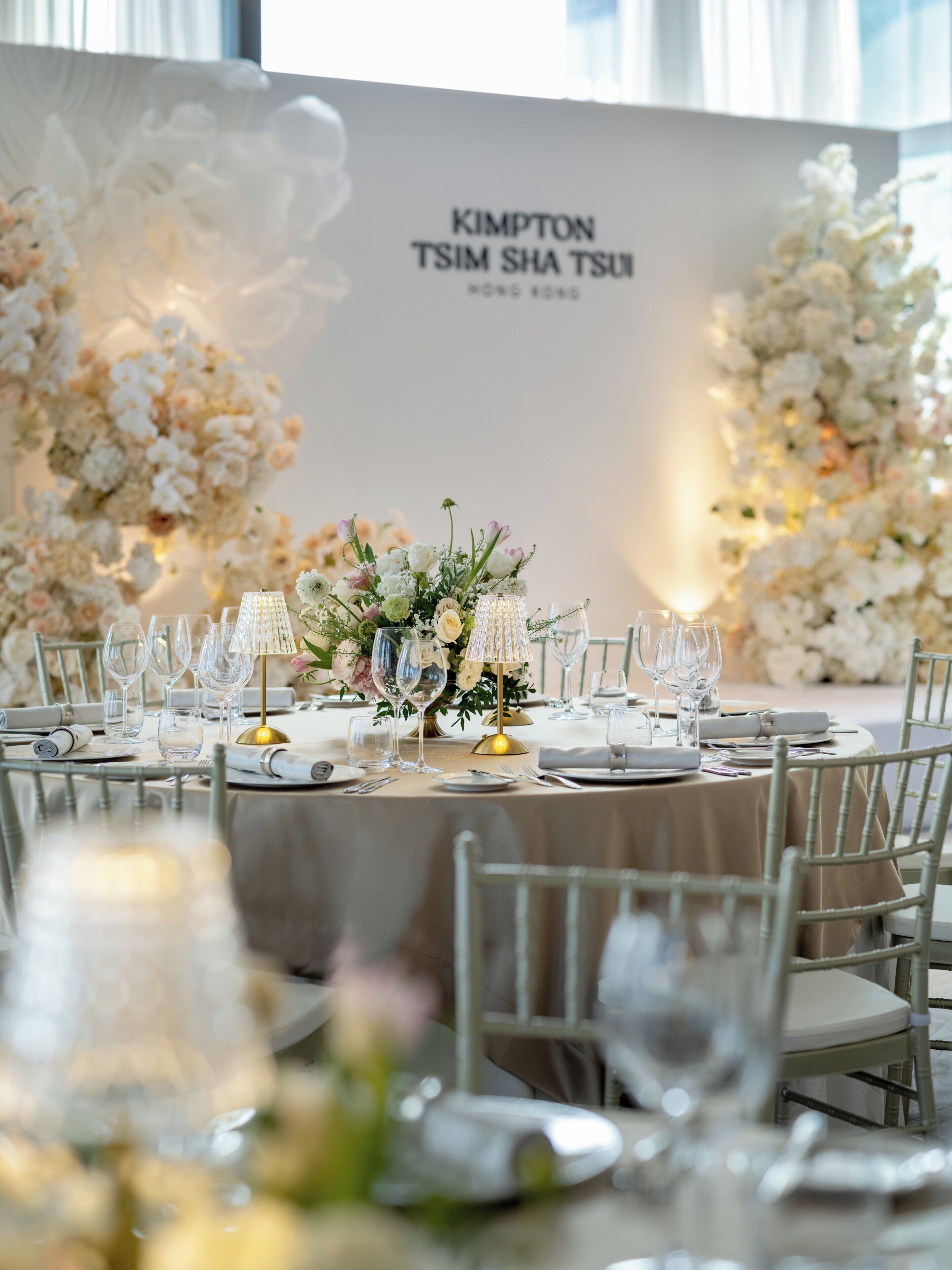 Une table de banquet dressée avec de la verrerie, des assiettes et un centre de table.