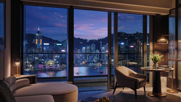 A modern living room with a large window overlooking a cityscape at night. - Kimpton Tsim Sha Tsui Hong Kong by IHG (Kowloon)