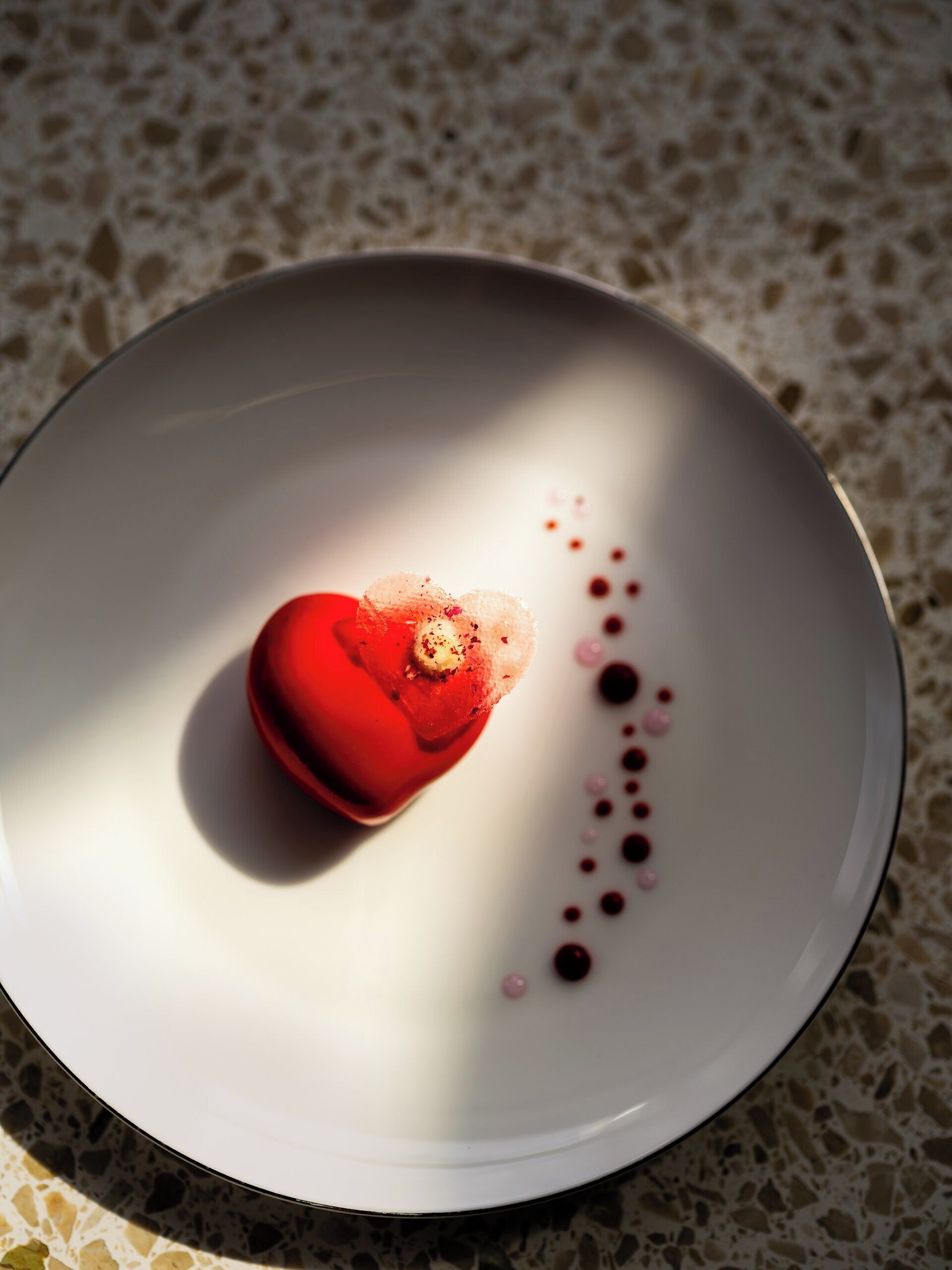 Un dessert servi dans une assiette blanche, sur laquelle on distingue un motif à points.