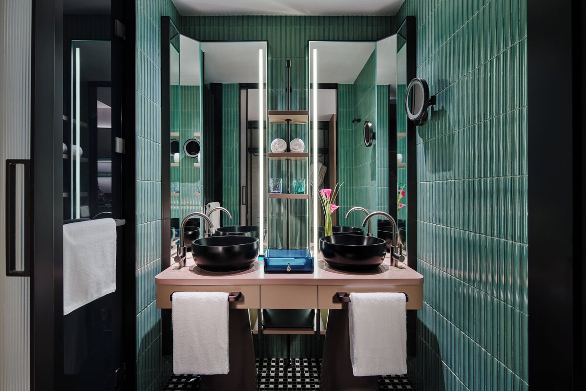 A bathroom with two sinks, a mirror, and a towel rack.