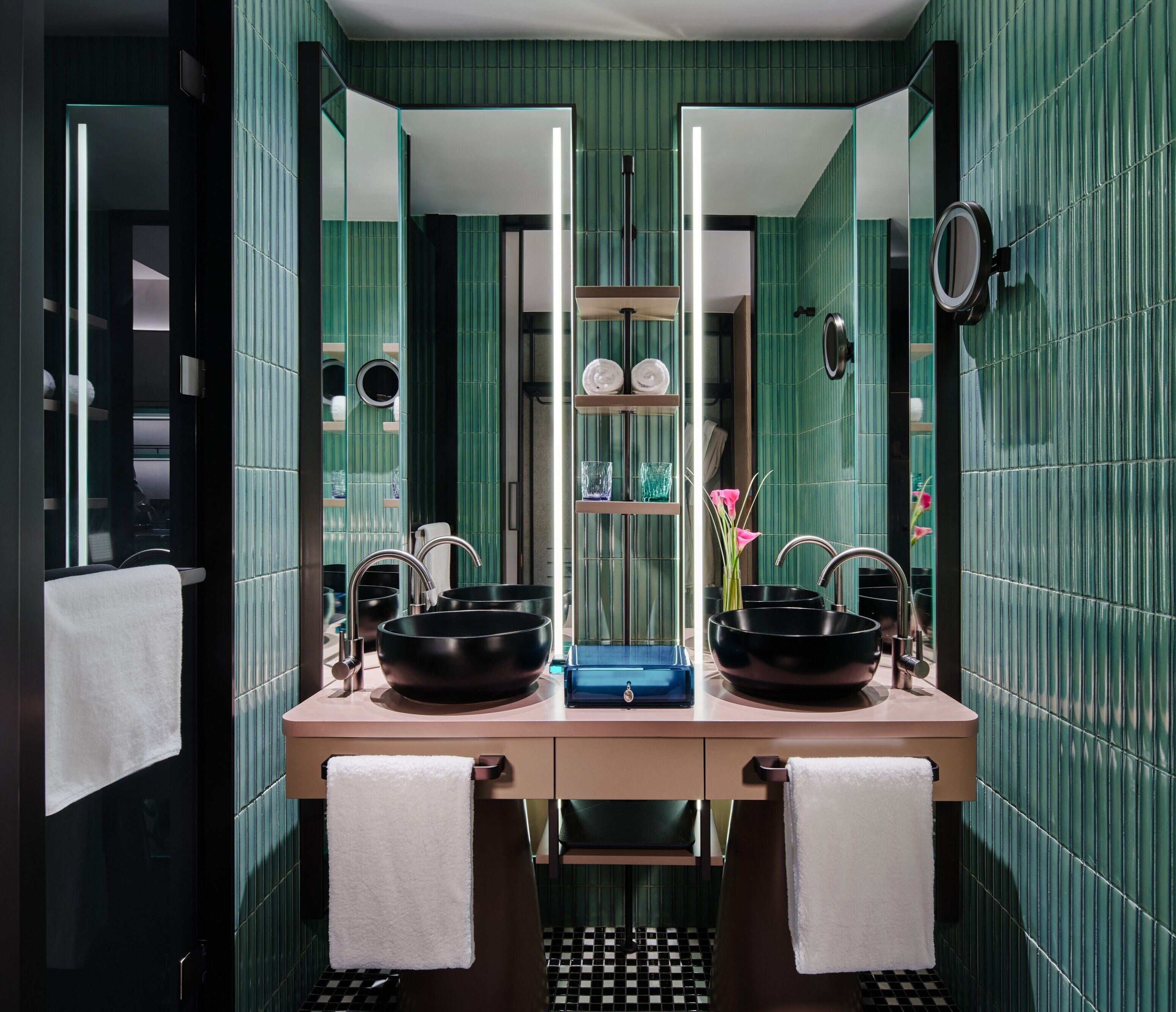 A modern bathroom with two sinks, a mirror, and a towel rack.