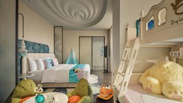 A hotel room with a bed, a bunk bed, a dining table, and a chair.