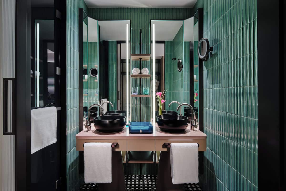 A bathroom with two sinks, a mirror, and a towel rack.