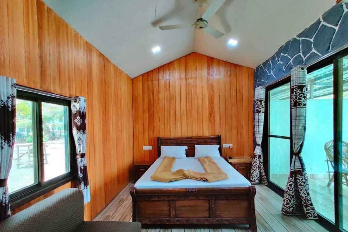A bedroom with a wooden bed, a ceiling fan, and large windows.