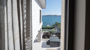 A balcony with a view of the sea, a small garden, and a hot tub. - Beachfront Villa Nautilux with Pool (Seget Donji)