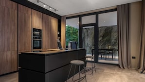 A modern kitchen with a central island, built-in appliances, and a large sliding glass door leading to an outdoor patio. - Luxury Villa Sylva with Pool (Grožnjan)