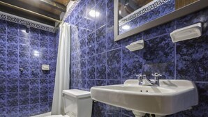 A bathroom with a white toilet, a white sink, and a shower curtain.