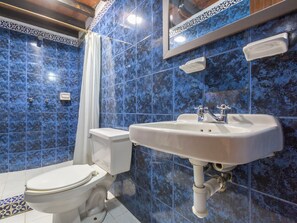 A bathroom with a toilet, sink, and shower.