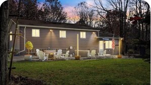 A two-story house with a well-maintained lawn and outdoor seating area. - sleeps six, close to slopes, hot tub and game room private hot tub (Albrightsville)